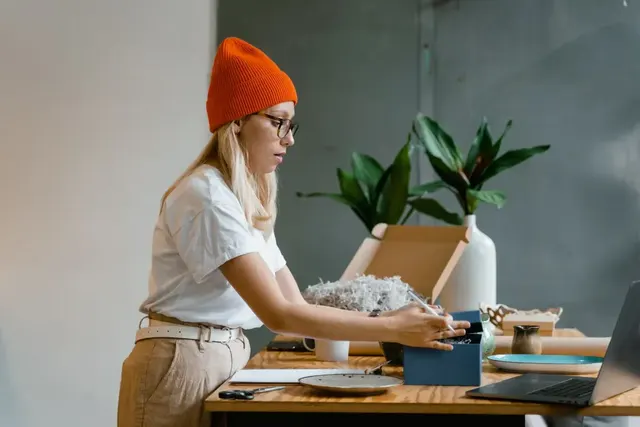 A young business owner packing an order at her worktable